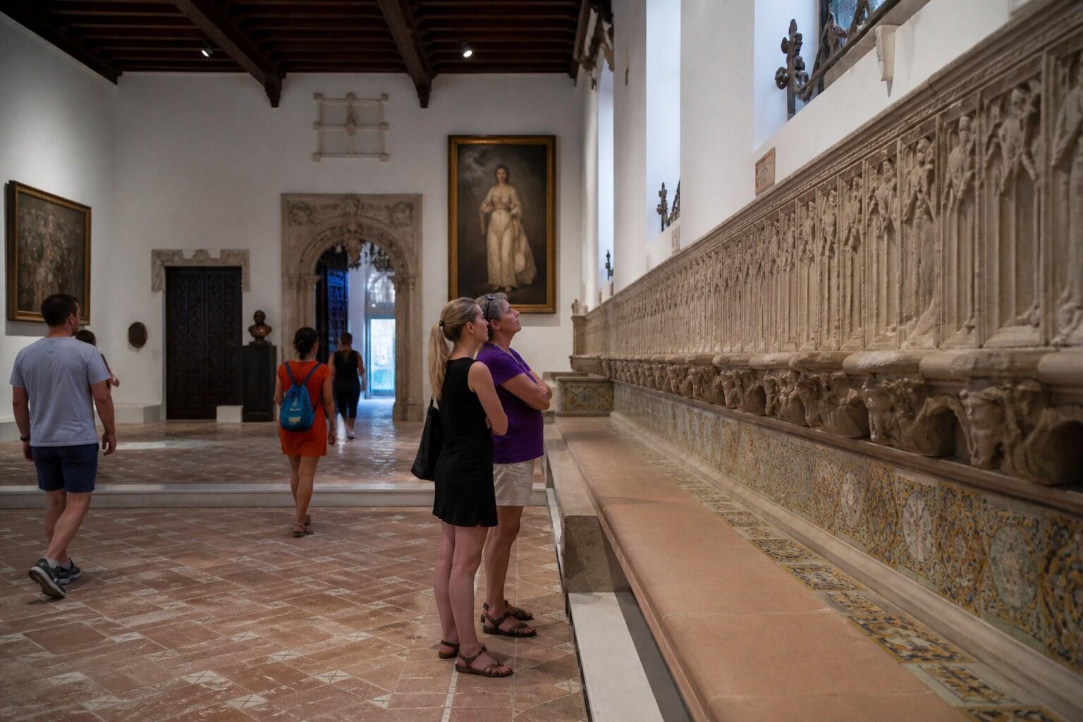 Visitors walking through a historic Sitges museum interior